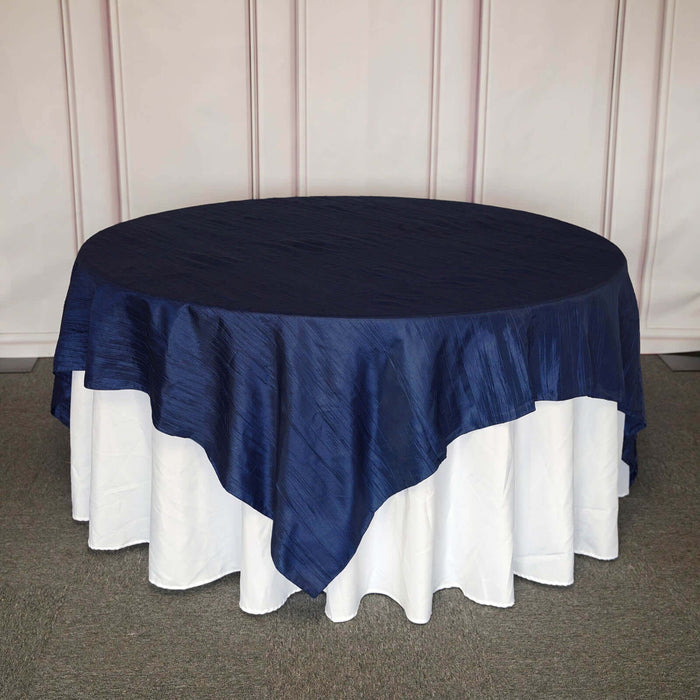 Navy blue round tablecloth on a white table.