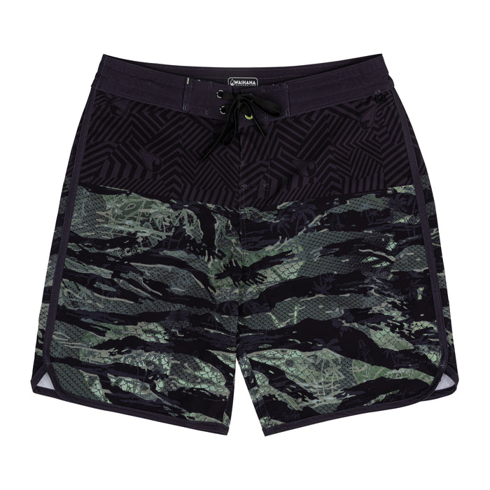 Waihana Tropicam W1 board shorts laid flat on a white background, showing a tiger-stripe camouflage print in green and black with a dark geometric upper panel and neon yellow accent drawstring.