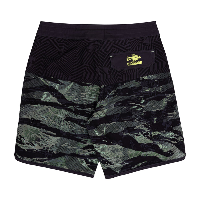 Back view of Waihana Tropicam W1 board shorts displaying a green tiger-stripe camo lower panel, black geometric tribal upper panel, and a yellow Waihana logo patch on the rear pocket.