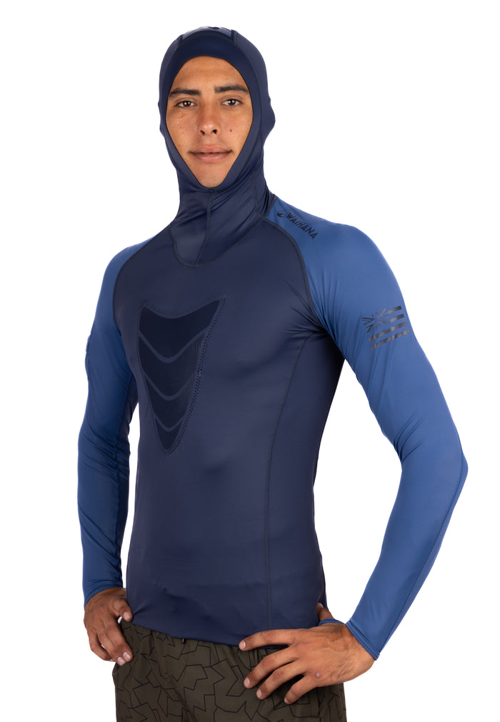 Male model wearing the Waihana Vista Hooded Spearfishing Rashguard in navy and steel blue, featuring a chest panel design and integrated hood, photographed from the front against a white background.
