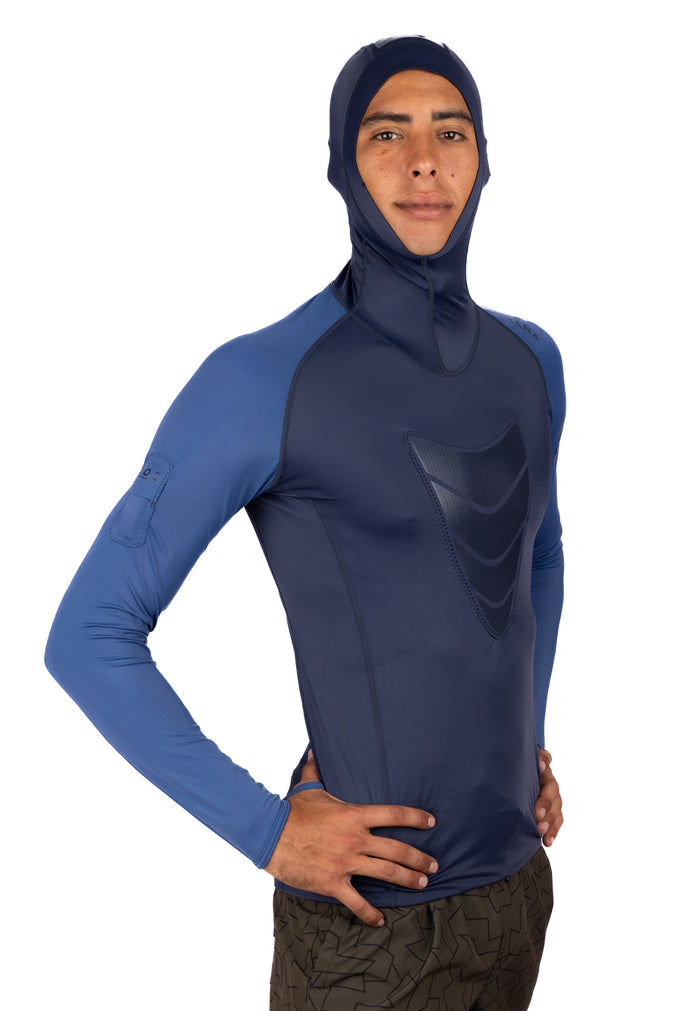 Male model wearing the Waihana Vista Hooded Spearfishing Rashguard in navy and blue colorblock with a textured chest panel and integrated hood, shown from the front on a white background.